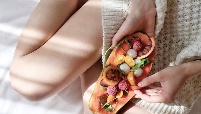 Ragazza con papaia e altri frutti